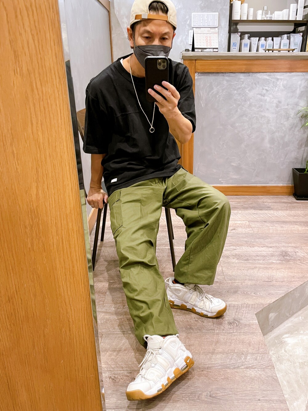 グリーン系のカーゴパンツ、ホワイト系のスニーカー、ブラック系のTシャツ/カットソーを着用したメンズの夏コーディネートの2枚目の写真