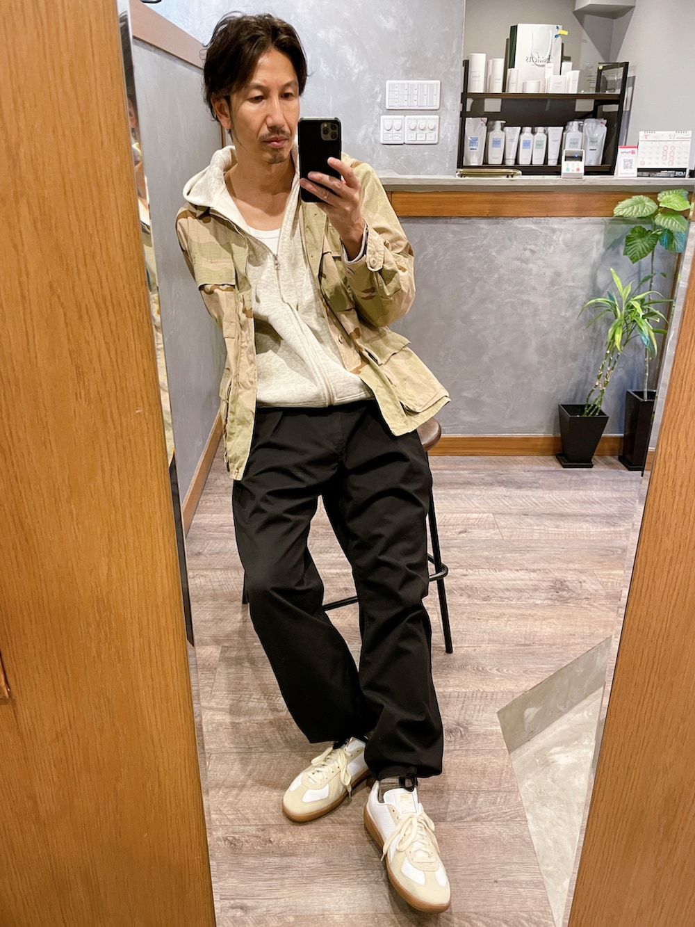 ホワイト系のスニーカー、ブルー系のパンツ、その他のミリタリージャケットを着用したメンズの秋コーディネートの3枚目の写真