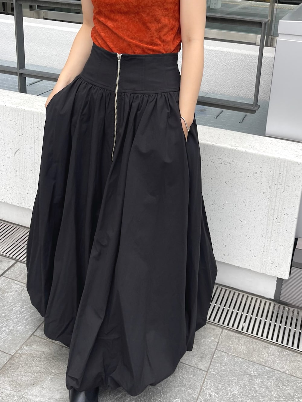 ブラウン系のタンクトップ、ブラック系のスカートを着用したレディースの夏コーディネートの3枚目の写真