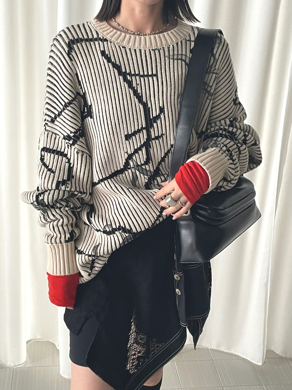 ベージュ系のニット/セーター、レッド系のTシャツ/カットソーを着用したレディースの秋コーディネートの2枚目の写真