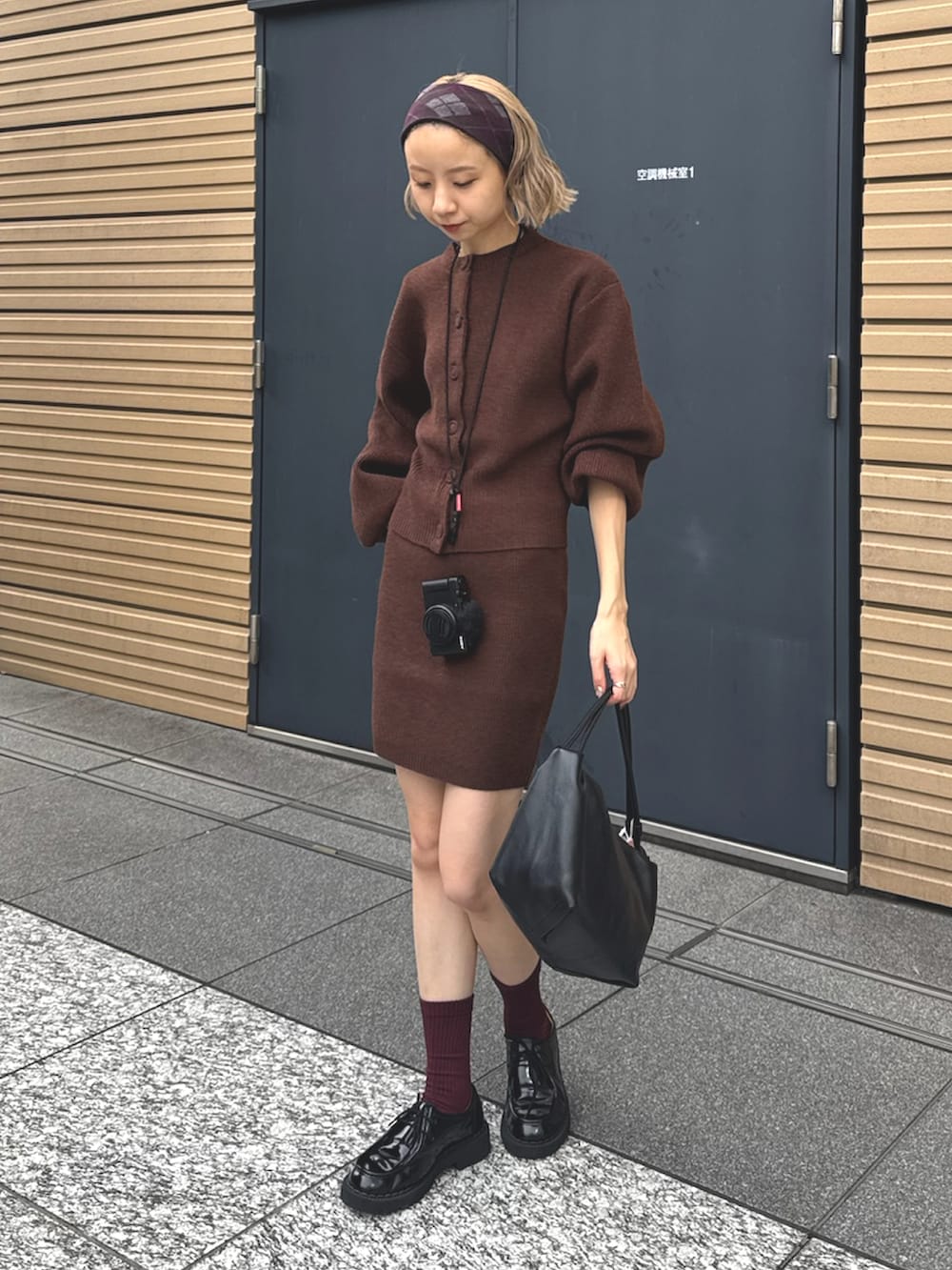 ブラウン系のニット/セーターを着用したレディースの秋コーディネートの2枚目の写真