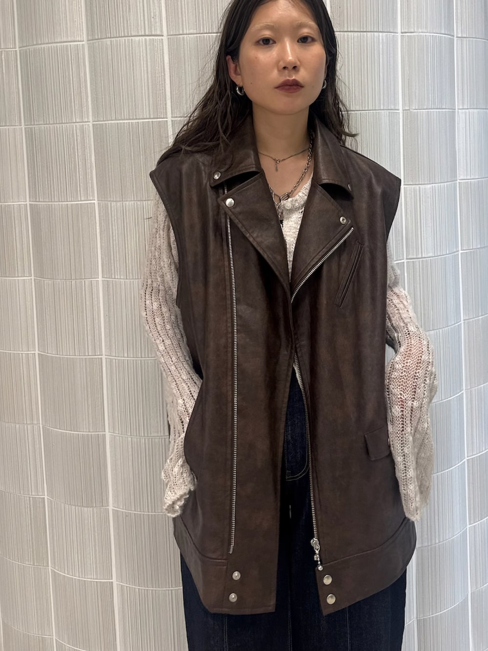 ブラウン系のライダースジャケット、ブラック系のブーツを着用したレディースの秋コーディネートの2枚目の写真