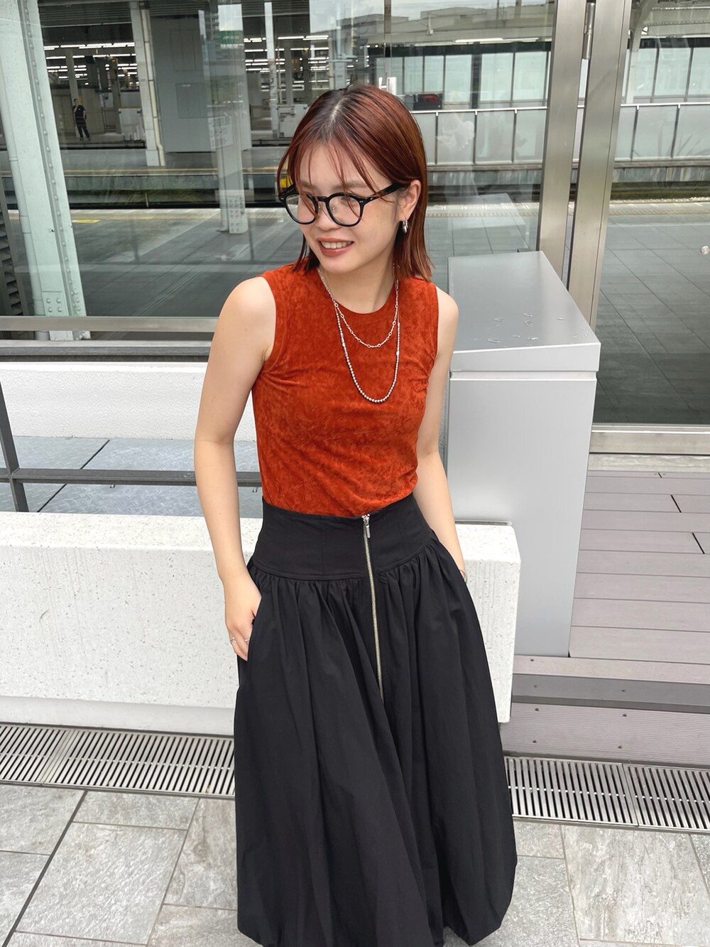 ブラウン系のタンクトップ、ブラック系のスカートを着用したレディースの夏コーディネートの4枚目の写真