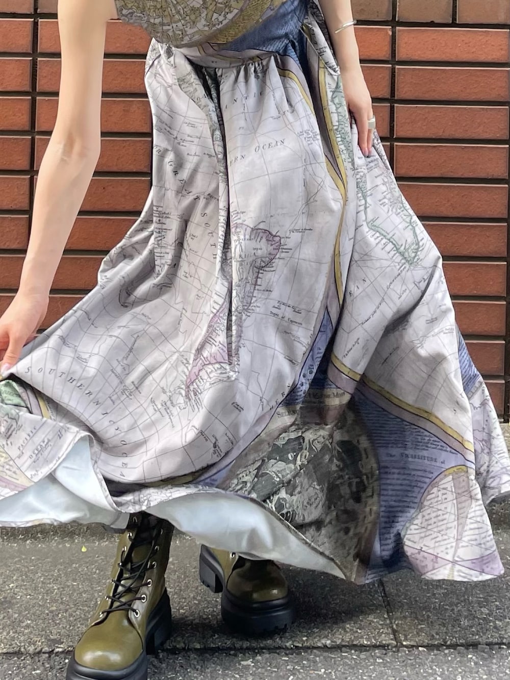 ブルー系のワンピース、グリーン系のブーツを着用したレディースの夏コーディネートの3枚目の写真