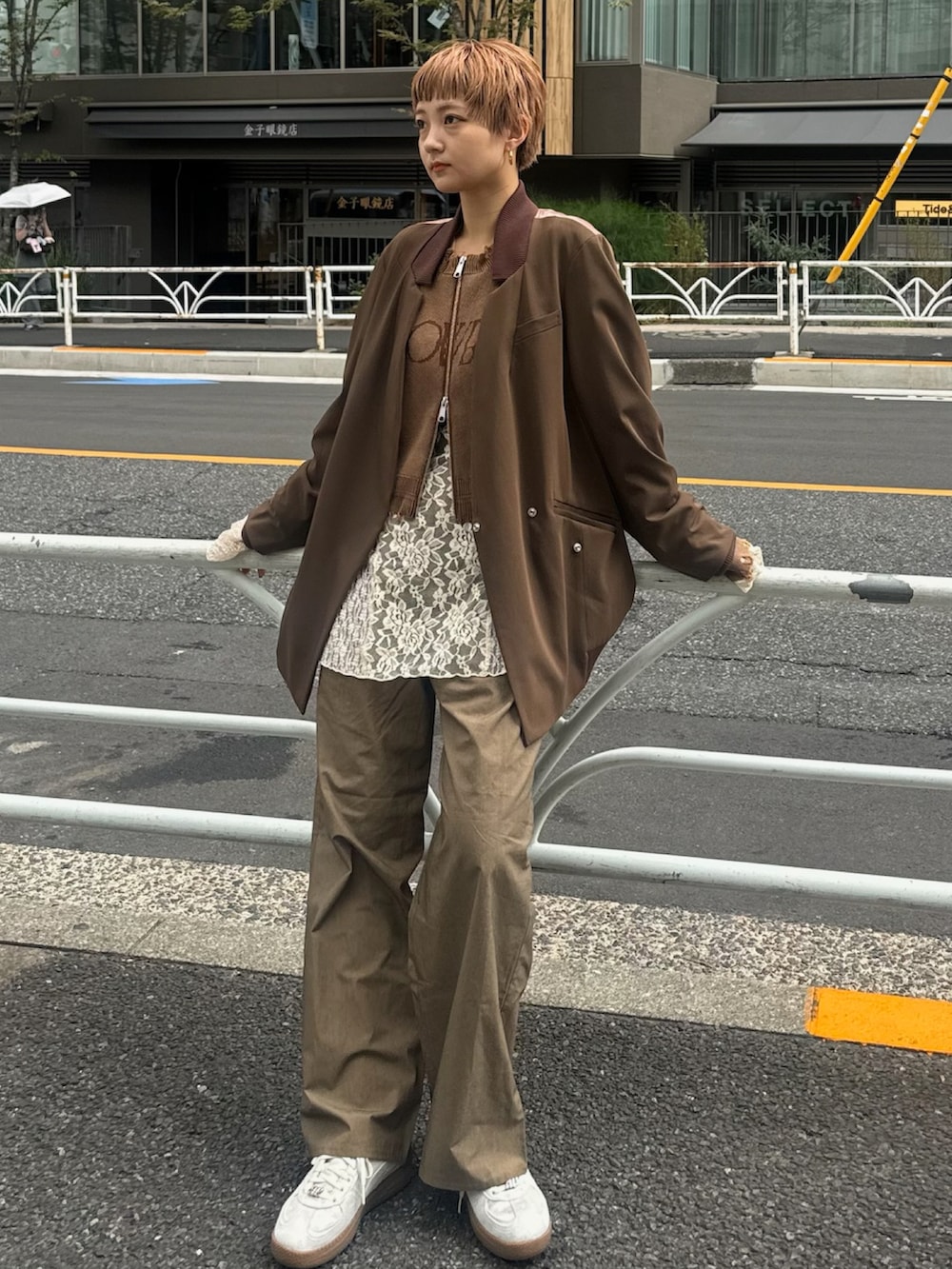 ホワイト系のTシャツ/カットソー、ブラウン系のニット/セーター、シルバー系のスニーカーを着用したレディースの秋コーディネートの5枚目の写真