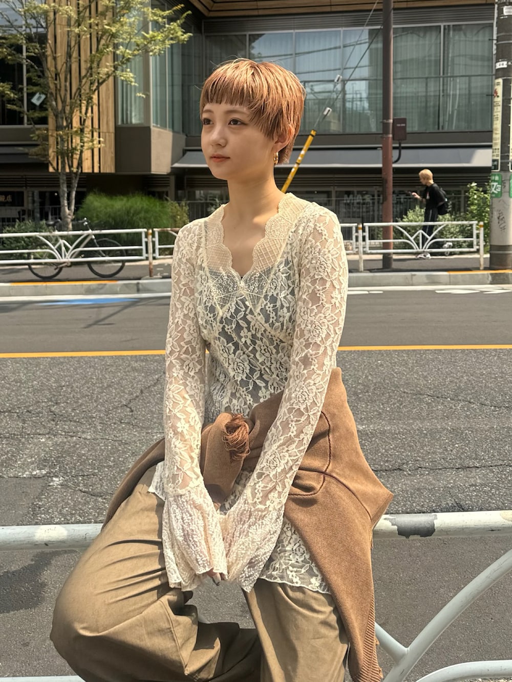 ホワイト系のTシャツ/カットソー、ブラウン系のニット/セーター、シルバー系のスニーカーを着用したレディースの秋コーディネートの2枚目の写真