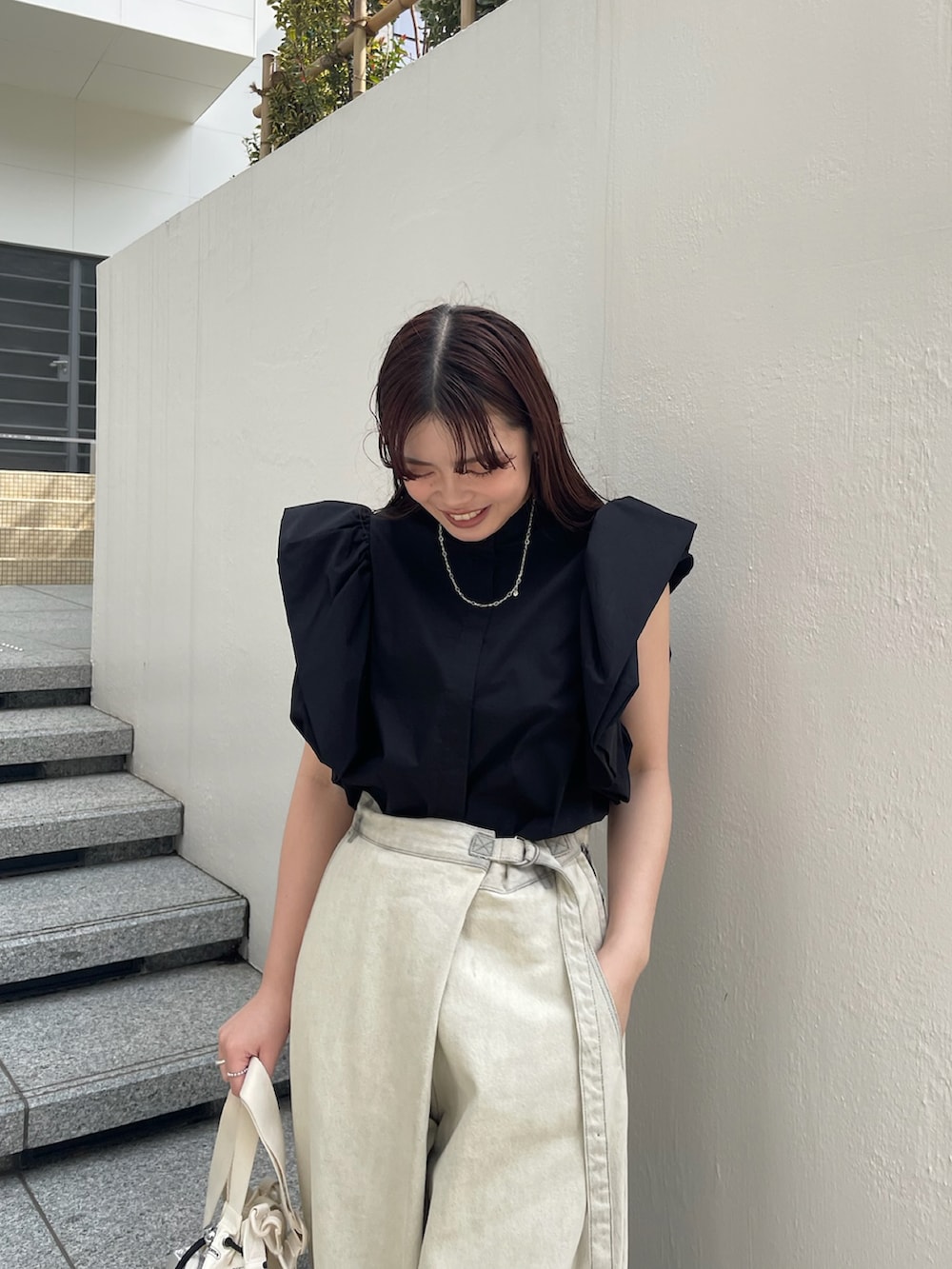 ブラック系のシャツ/ブラウス、ホワイト系のデニムパンツ、ホワイト系のバッグを着用したレディースの春コーディネートの4枚目の写真