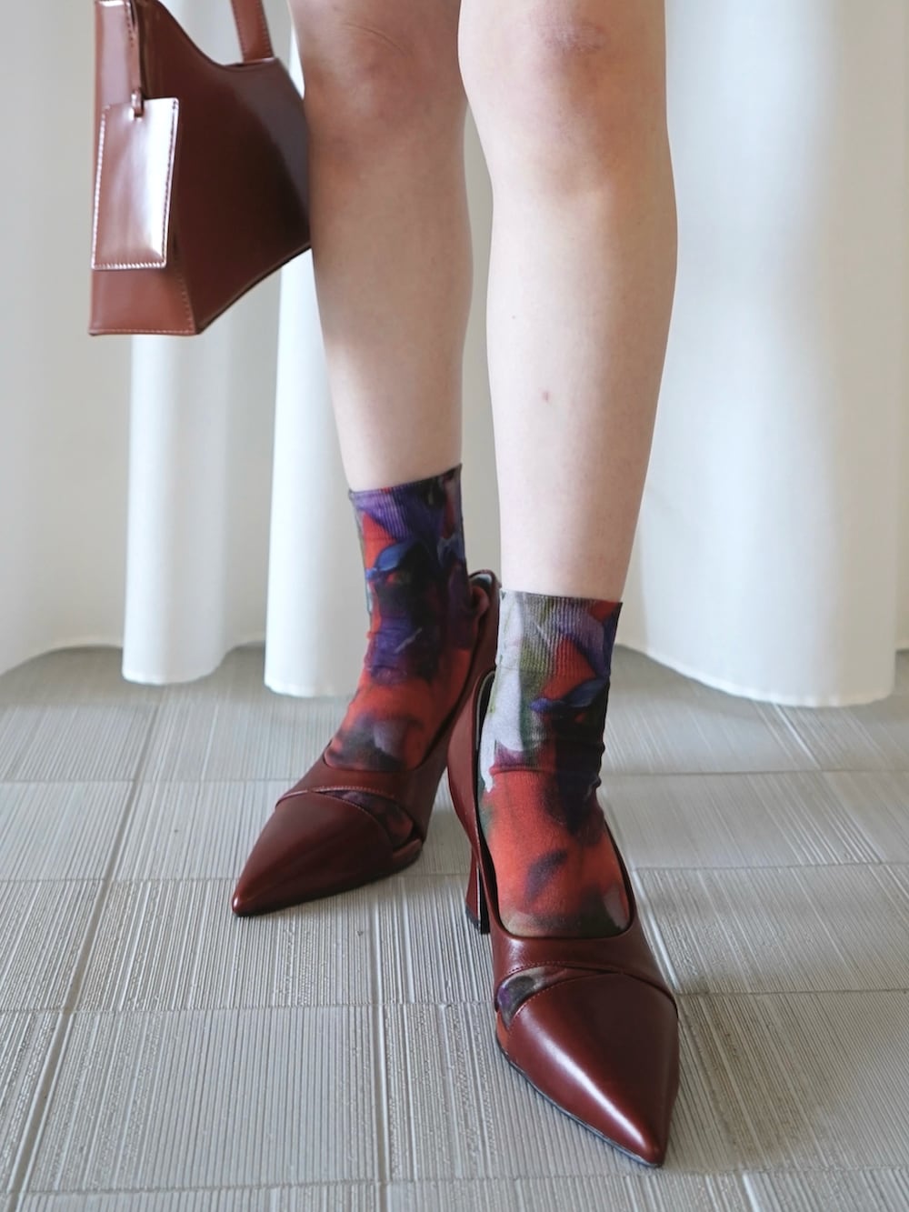 ブラウン系のバッグ、ブルー系のその他パンツ、レッド系のニット/セーターを着用したレディースの春コーディネートの2枚目の写真