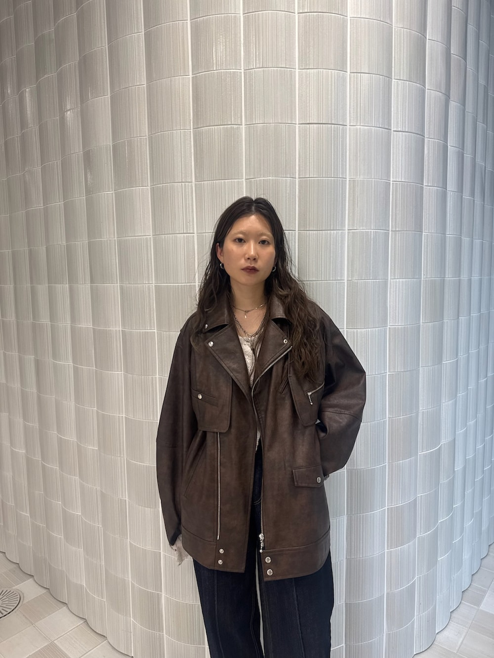 ブラウン系のライダースジャケット、ブラック系のブーツを着用したレディースの秋コーディネートの4枚目の写真