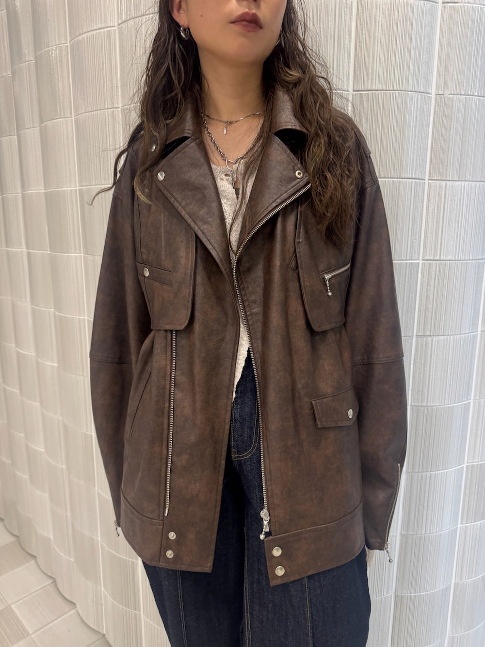 ブラウン系のライダースジャケット、ブラック系のブーツを着用したレディースの秋コーディネートの3枚目の写真