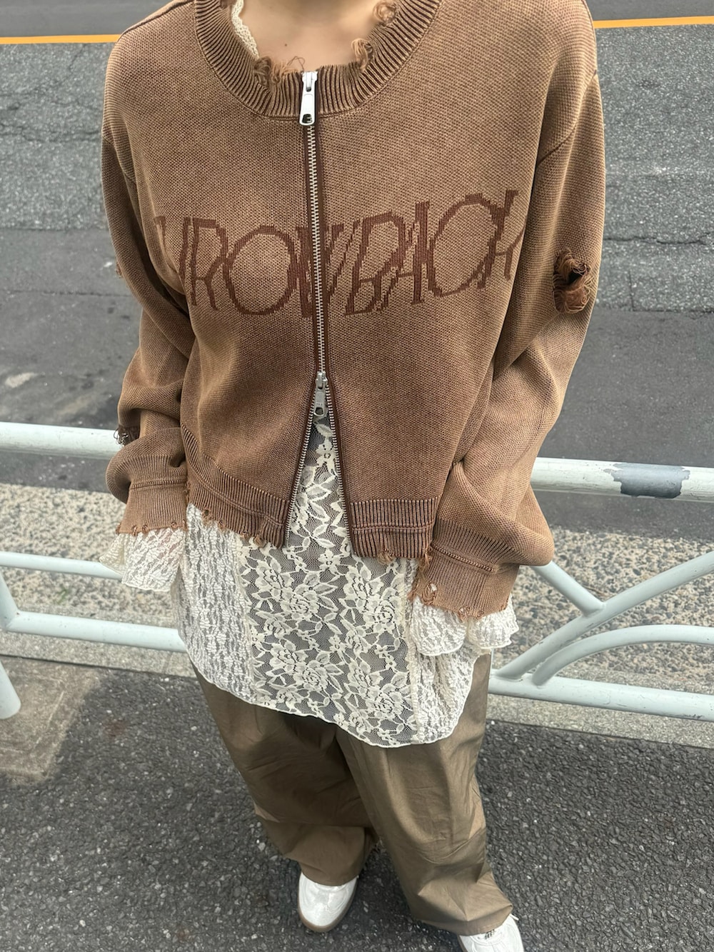 ホワイト系のTシャツ/カットソー、ブラウン系のニット/セーター、シルバー系のスニーカーを着用したレディースの秋コーディネートの4枚目の写真