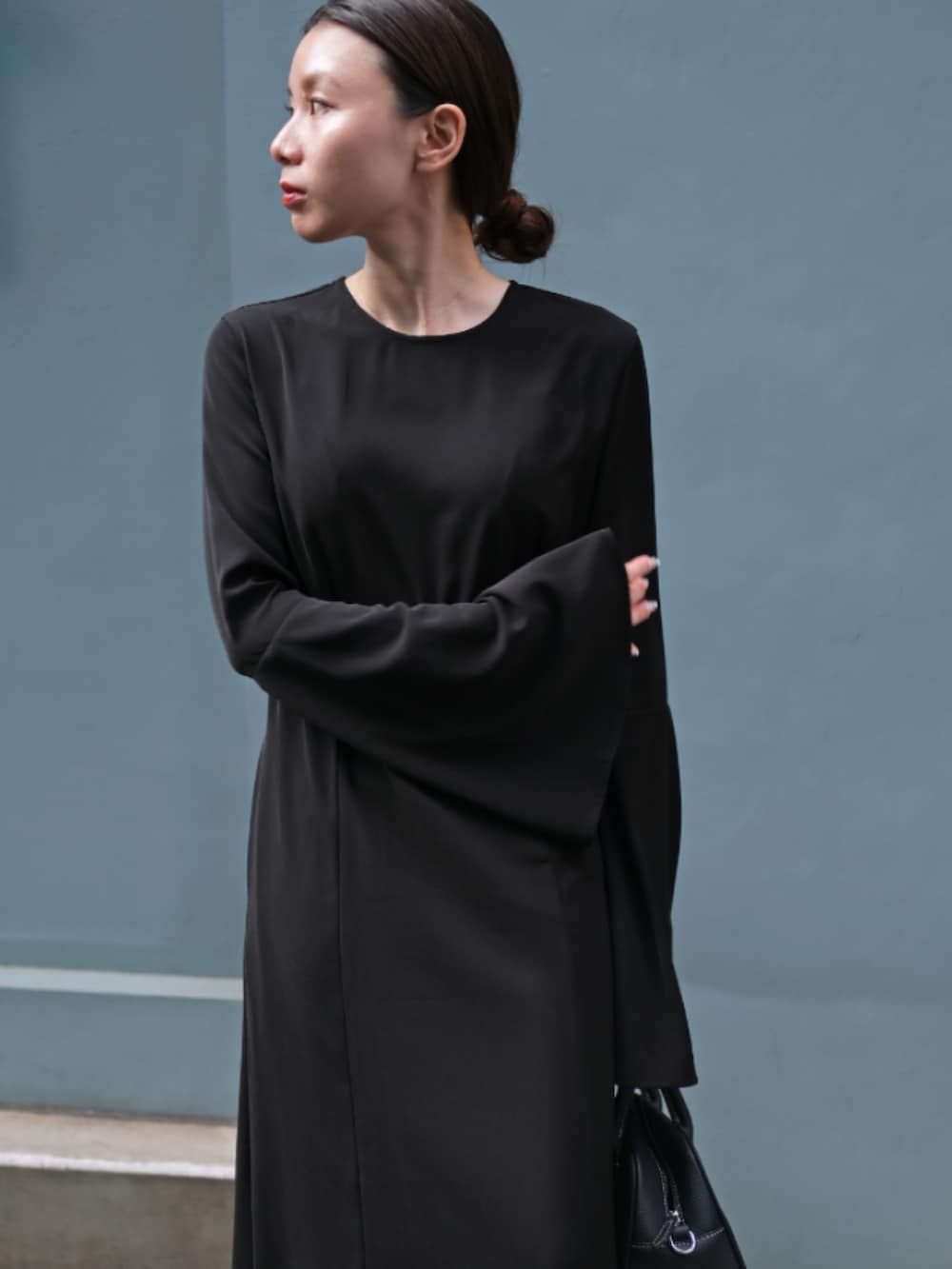 ブラック系のワンピースを着用したレディースの秋コーディネートの2枚目の写真