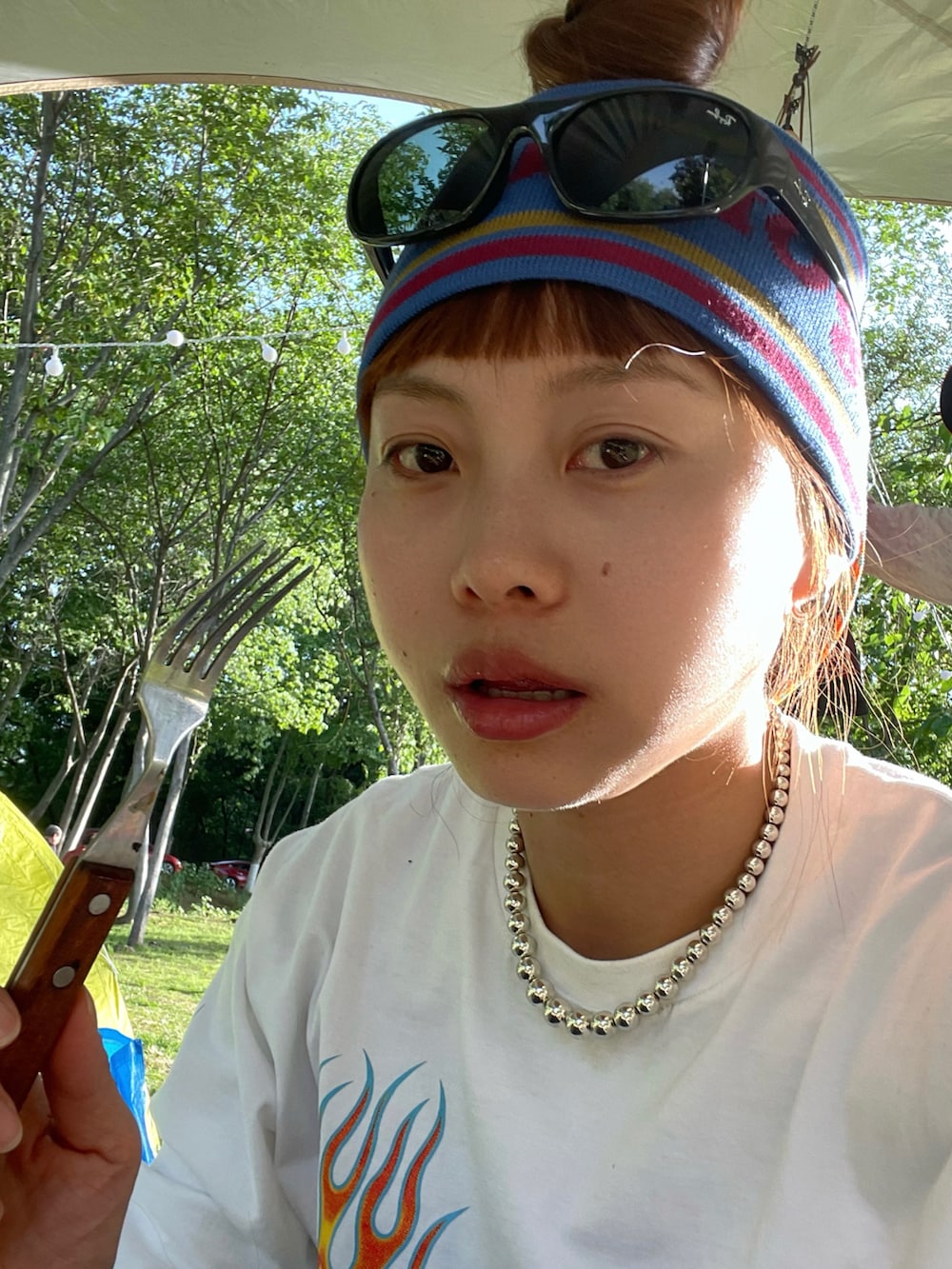 ブルー系のデニムパンツ、ブラウン系のスニーカー、ホワイト系のTシャツ/カットソーを着用したレディースの春コーディネートの2枚目の写真