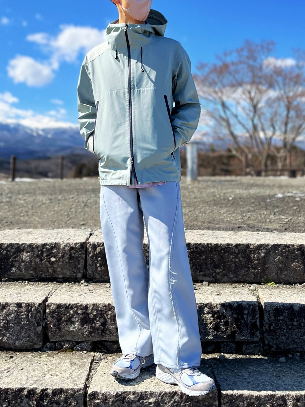 グリーン系のブルゾン、パープル系のシャツ/ブラウス、ブルー系のスラックスを着用したメンズの春コーディネートの2枚目の写真