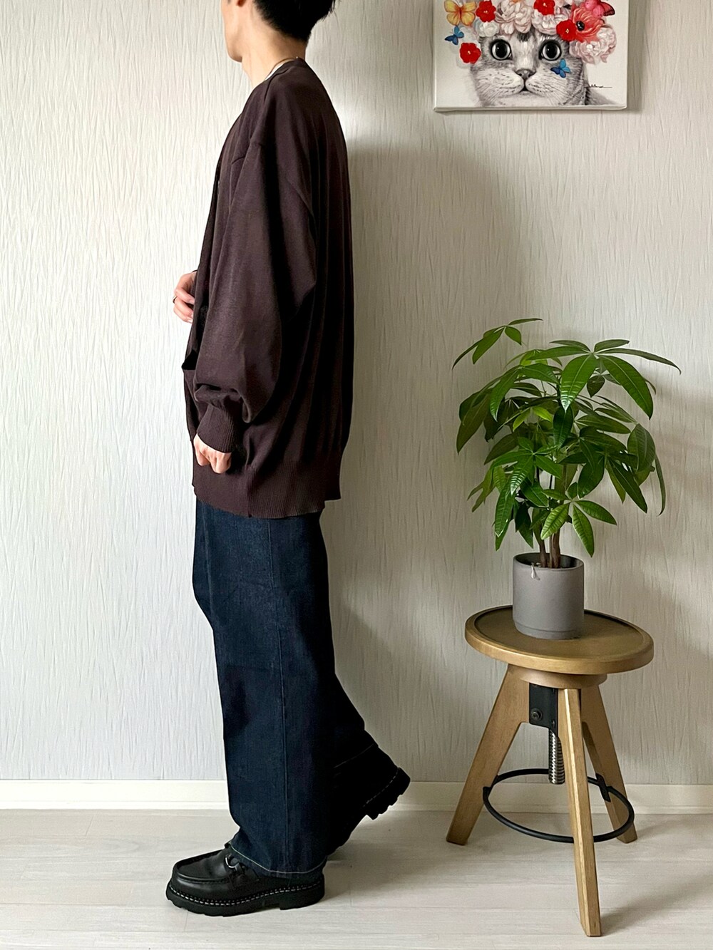 ブラウン系のニット/セーター、ホワイト系のTシャツ/カットソー、ブルー系のデニムパンツを着用したメンズの秋コーディネートの2枚目の写真