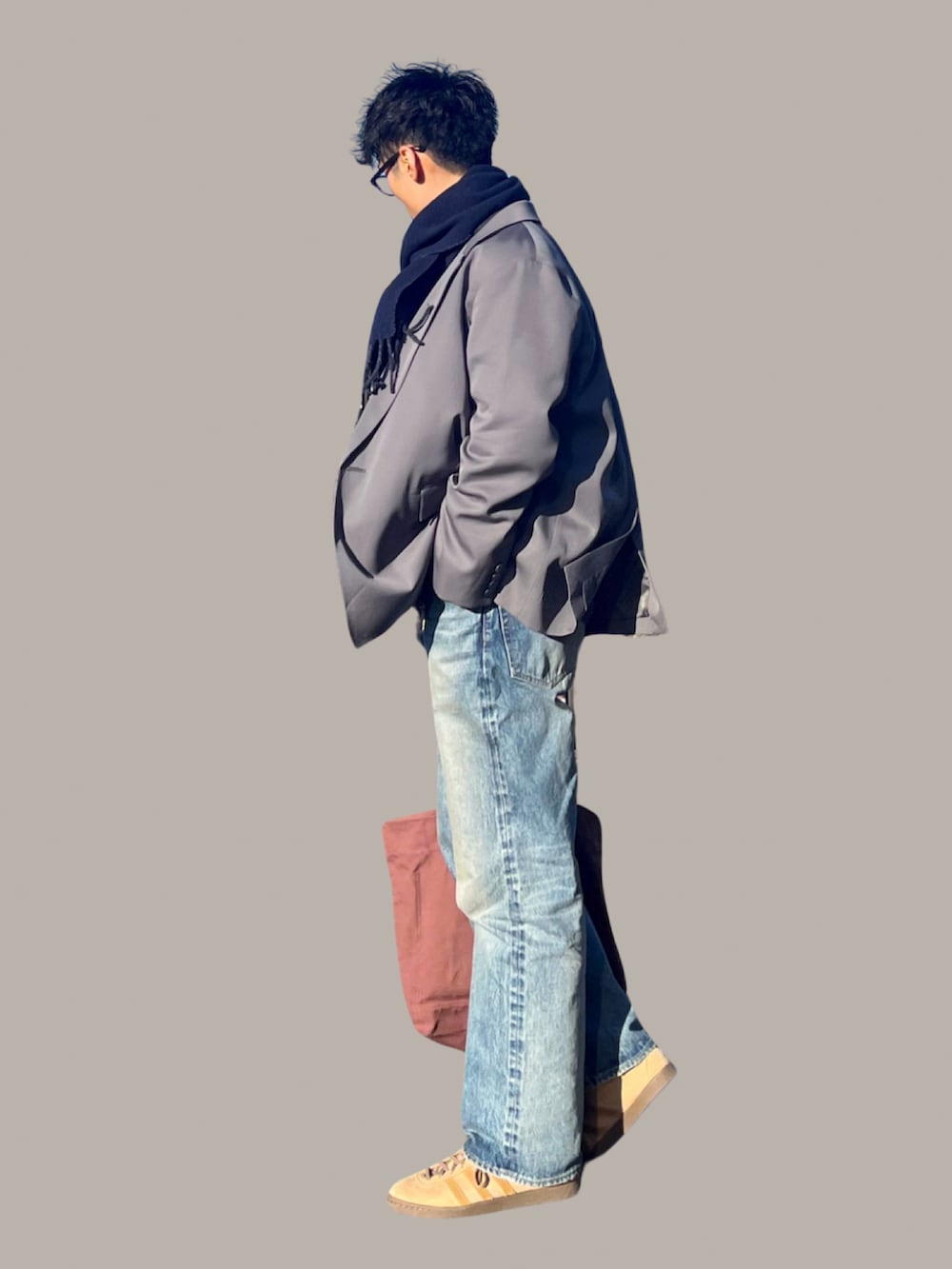 ブルー系のデニムパンツ、グレー系のテーラードジャケット、グレー系のニット/セーターを着用したメンズの冬コーディネートの3枚目の写真