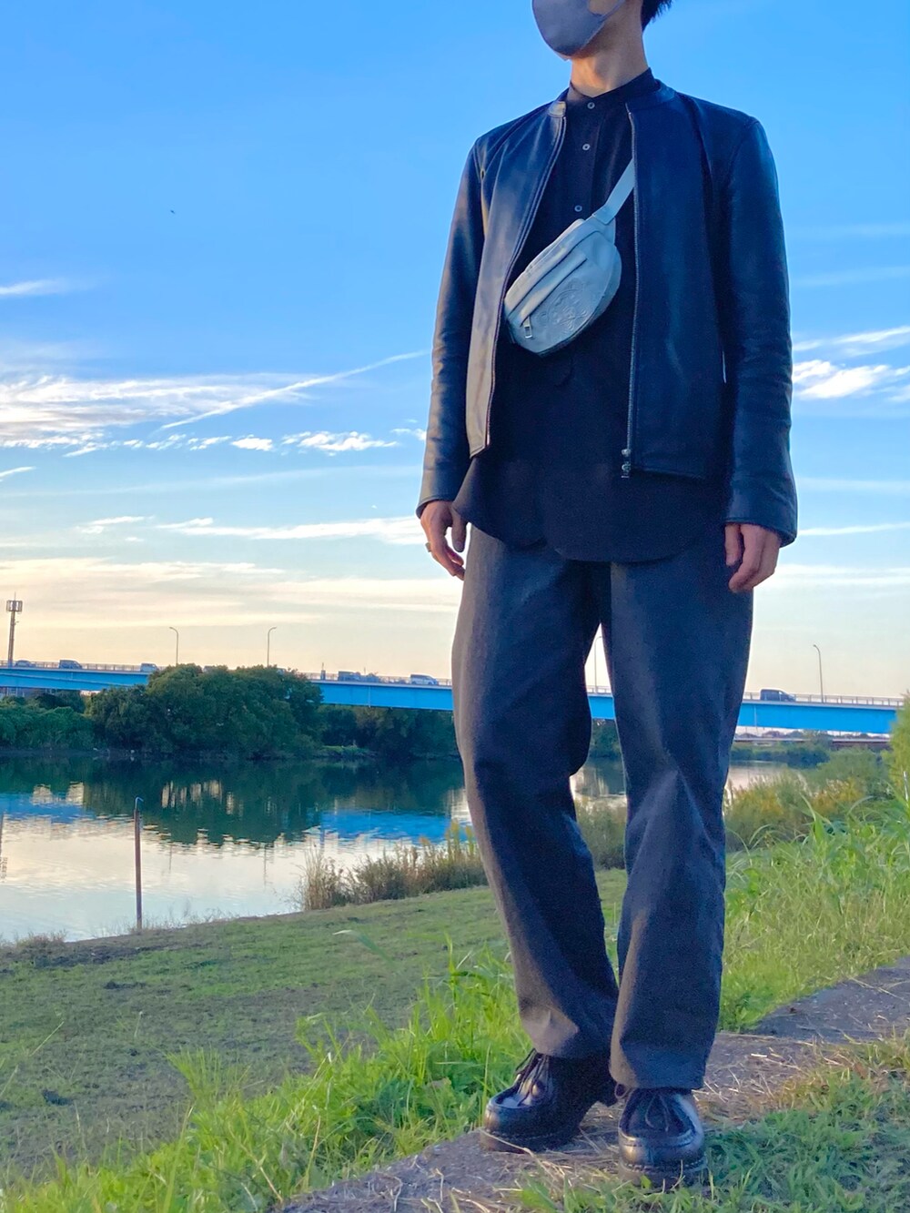 ブラック系のライダースジャケット、ブラウン系のシャツ/ブラウス、ブルー系のボディバッグ/ウエストポーチを着用したメンズの秋コーディネートの2枚目の写真