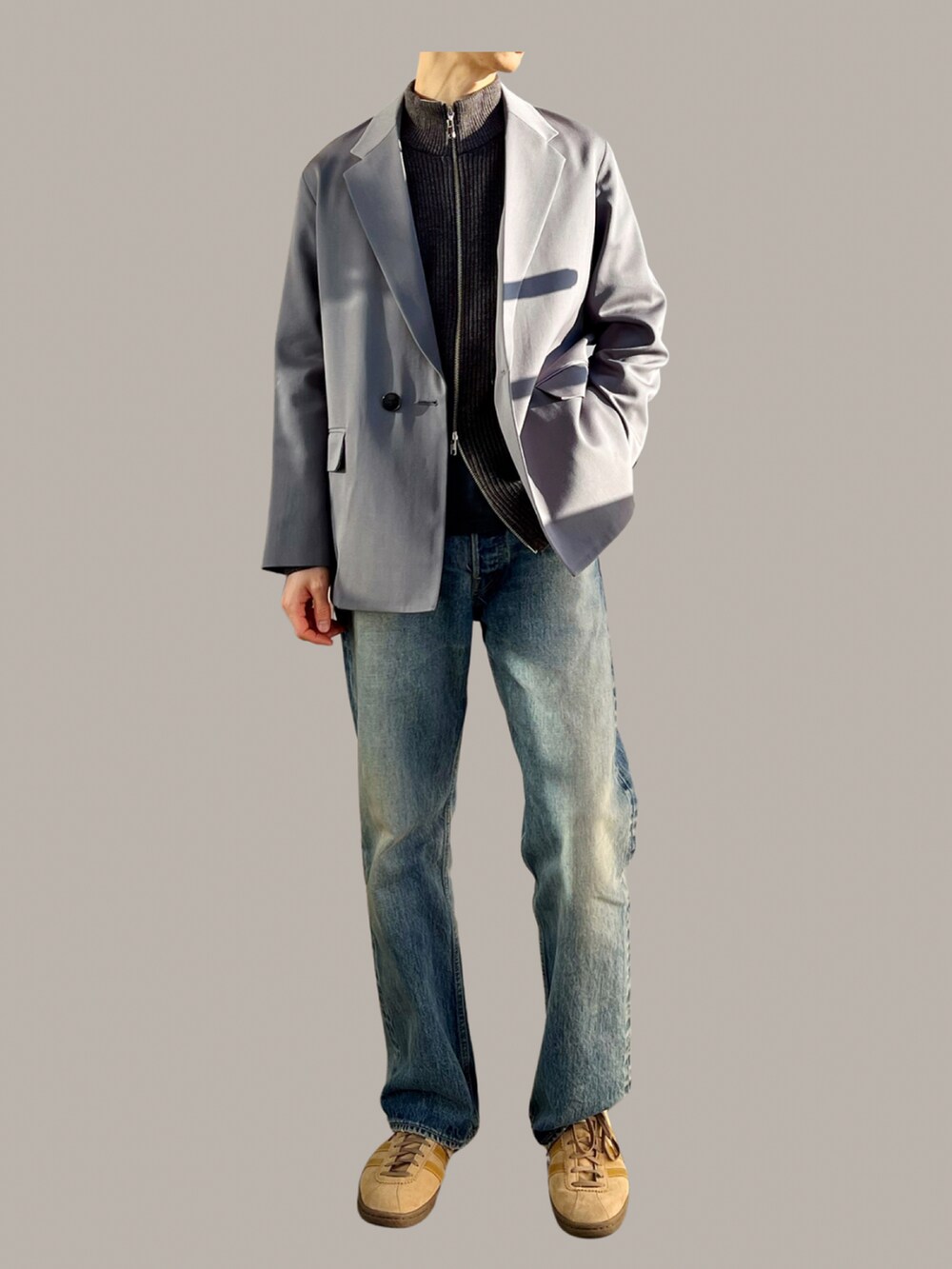 ブルー系のデニムパンツ、グレー系のテーラードジャケット、グレー系のニット/セーターを着用したメンズの冬コーディネートの2枚目の写真