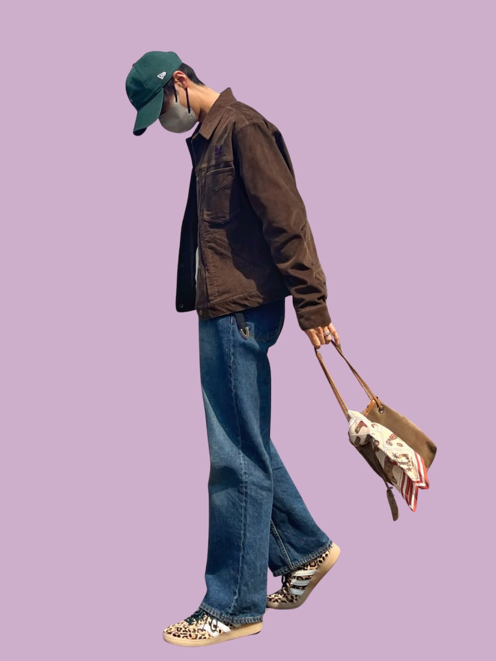 ベージュ系のハンドバッグ、ベージュ系のスニーカー、ブルー系のデニムパンツを着用したメンズの春コーディネートの2枚目の写真