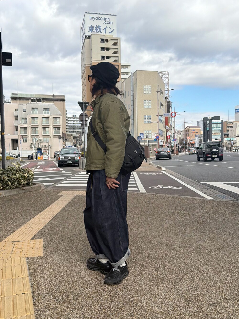 グリーン系のその他アウター、ブラック系のシューズ、ブラック系のキャップを着用したメンズの冬コーディネートの2枚目の写真