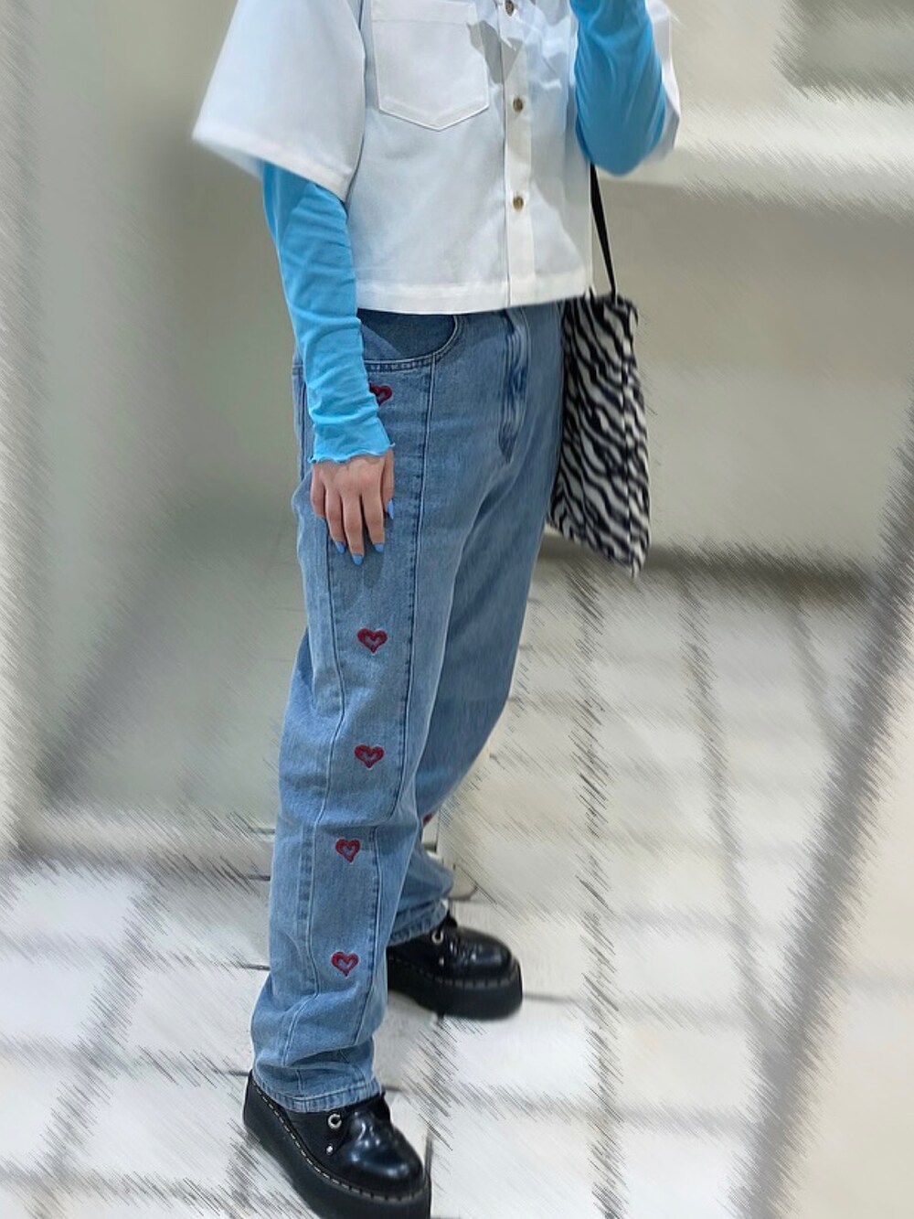 ブルー系のデニムパンツ、ブラック系のブーツ、ホワイト系のシャツ/ブラウスを着用したレディースの夏コーディネートの2枚目の写真