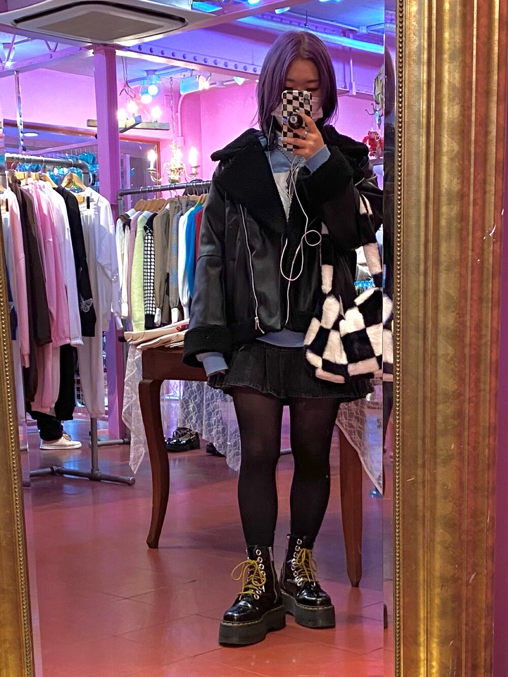 ブルー系のスウェット、ブラック系のジャケット/アウター、グレー系のデニムスカートを着用したレディースの冬コーディネートの2枚目の写真