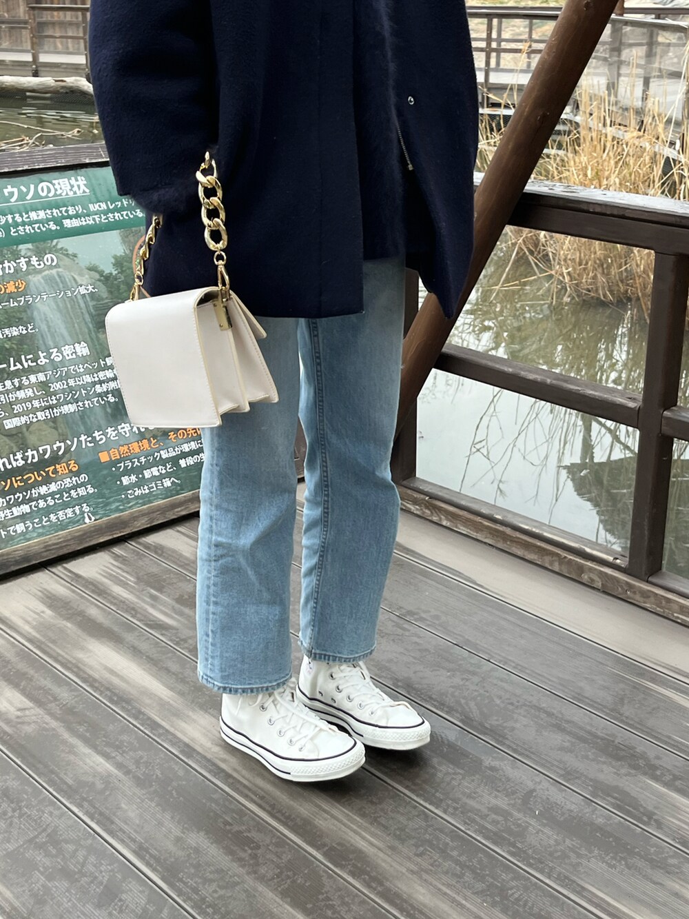 ベージュ系のノーカラージャケット、ブルー系のニット/セーター、ブルー系のデニムパンツを着用したレディースの冬コーディネートの2枚目の写真