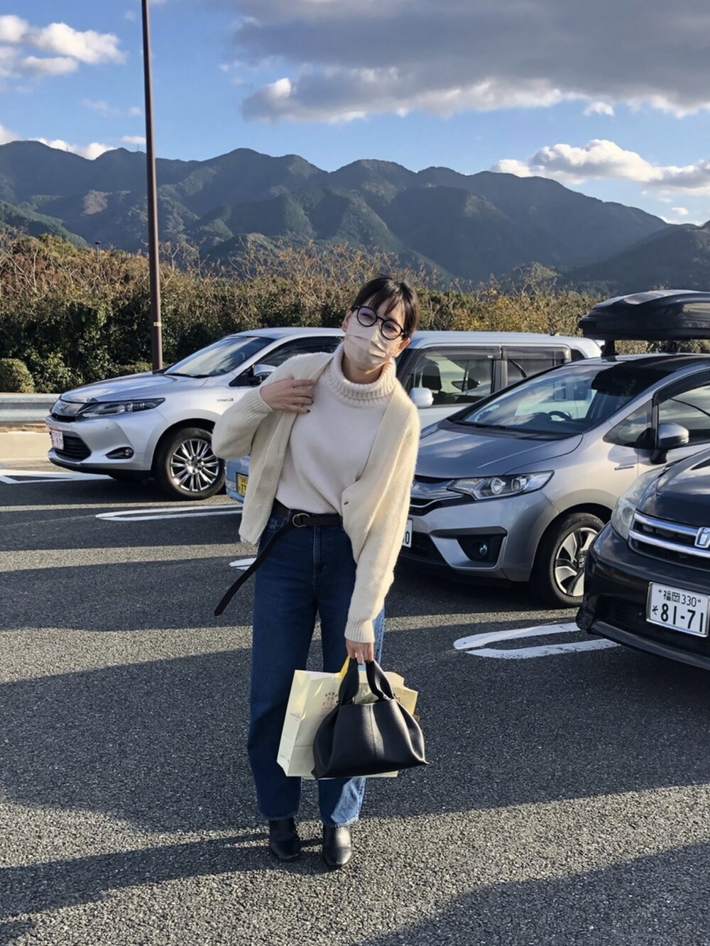 ホワイト系のニット/セーター、ホワイト系のカーディガン/ボレロ、ブラック系のバッグを着用したレディースの秋コーディネートの2枚目の写真