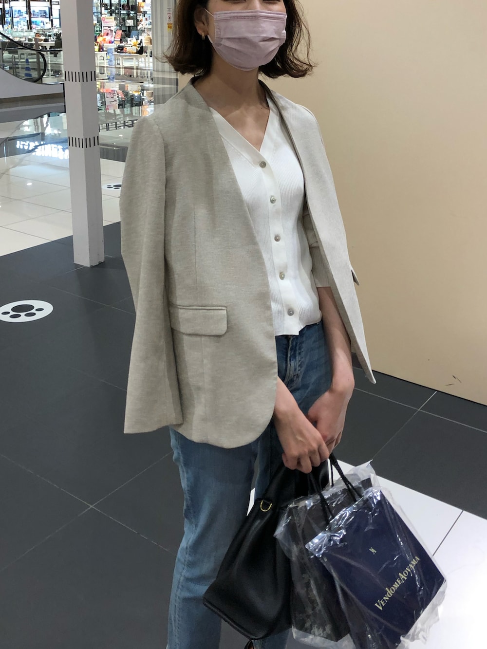 ブラック系のサンダル、ブルー系のデニムパンツ、ブラック系のバッグを着用したレディースの秋コーディネートの2枚目の写真