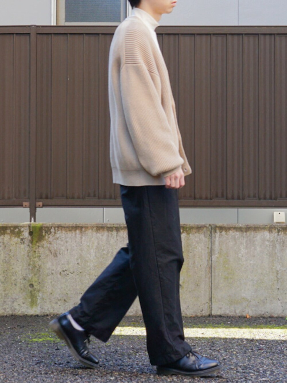 ベージュ系のカーディガン/ボレロ、ホワイト系のTシャツ/カットソー、ブラック系のパンツを着用したメンズの秋コーディネートの3枚目の写真