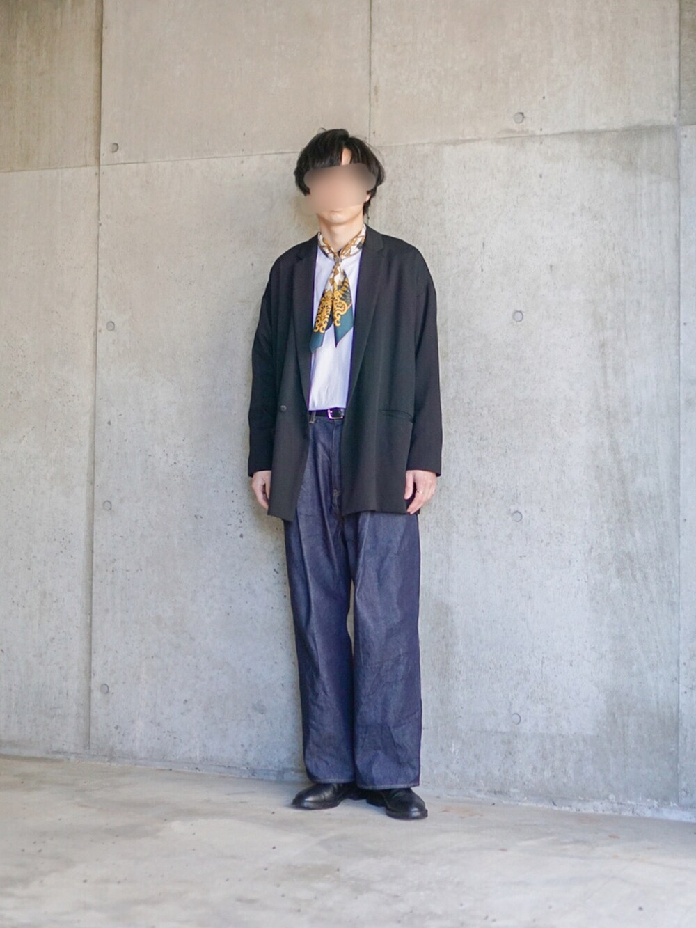 ブラック系のテーラードジャケット、ホワイト系のTシャツ/カットソー、ブルー系のデニムパンツを着用したメンズの春コーディネートの5枚目の写真