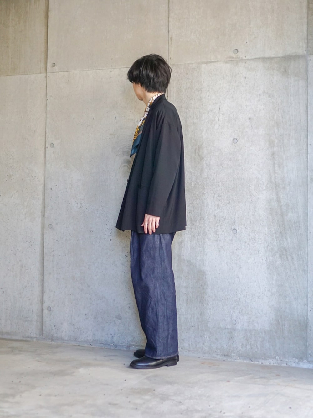 ブラック系のテーラードジャケット、ホワイト系のTシャツ/カットソー、ブルー系のデニムパンツを着用したメンズの春コーディネートの3枚目の写真