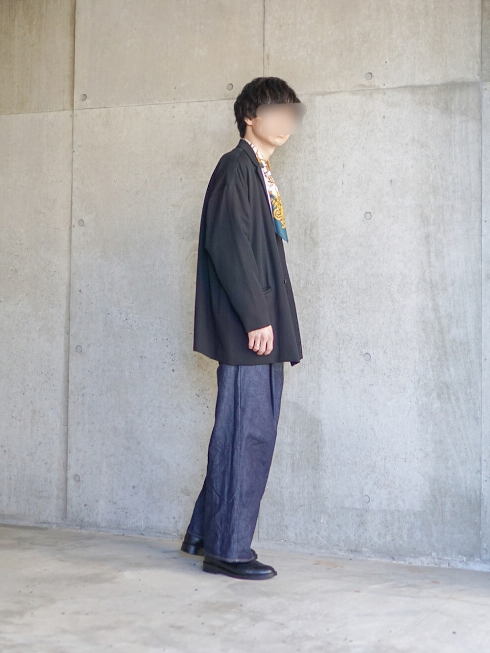 ブラック系のテーラードジャケット、ホワイト系のTシャツ/カットソー、ブルー系のデニムパンツを着用したメンズの春コーディネートの2枚目の写真