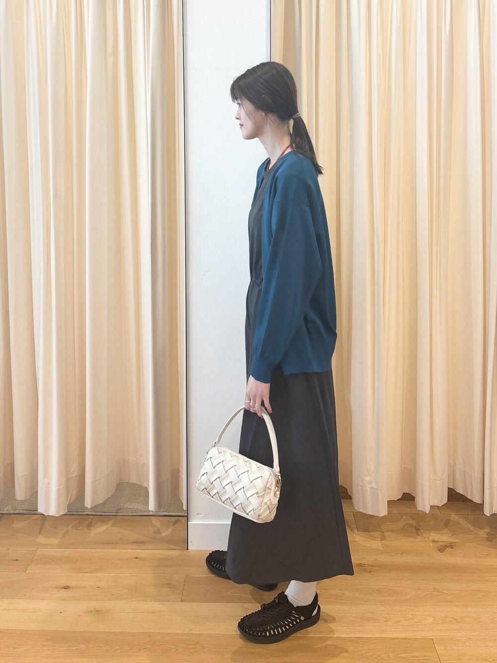 ホワイト系のショルダーバッグ、ブルー系のカーディガン/ボレロ、グレー系のワンピースを着用したレディースの夏コーディネートの6枚目の写真