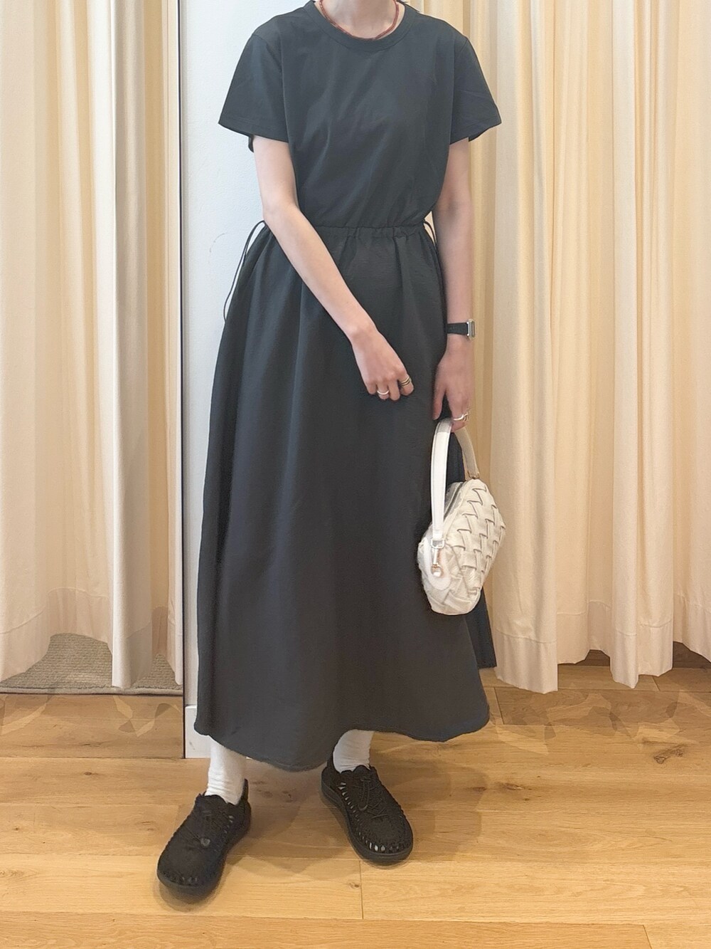 ホワイト系のショルダーバッグ、ブルー系のカーディガン/ボレロ、グレー系のワンピースを着用したレディースの夏コーディネートの4枚目の写真