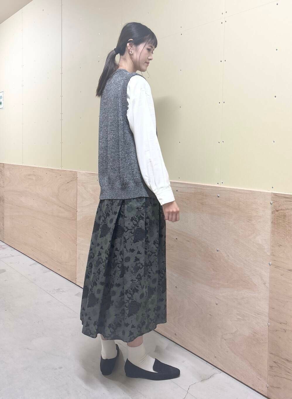 ベージュ系のショルダーバッグ、ブラック系のスカート、ブラック系のローファーを着用したレディースの秋コーディネートの2枚目の写真