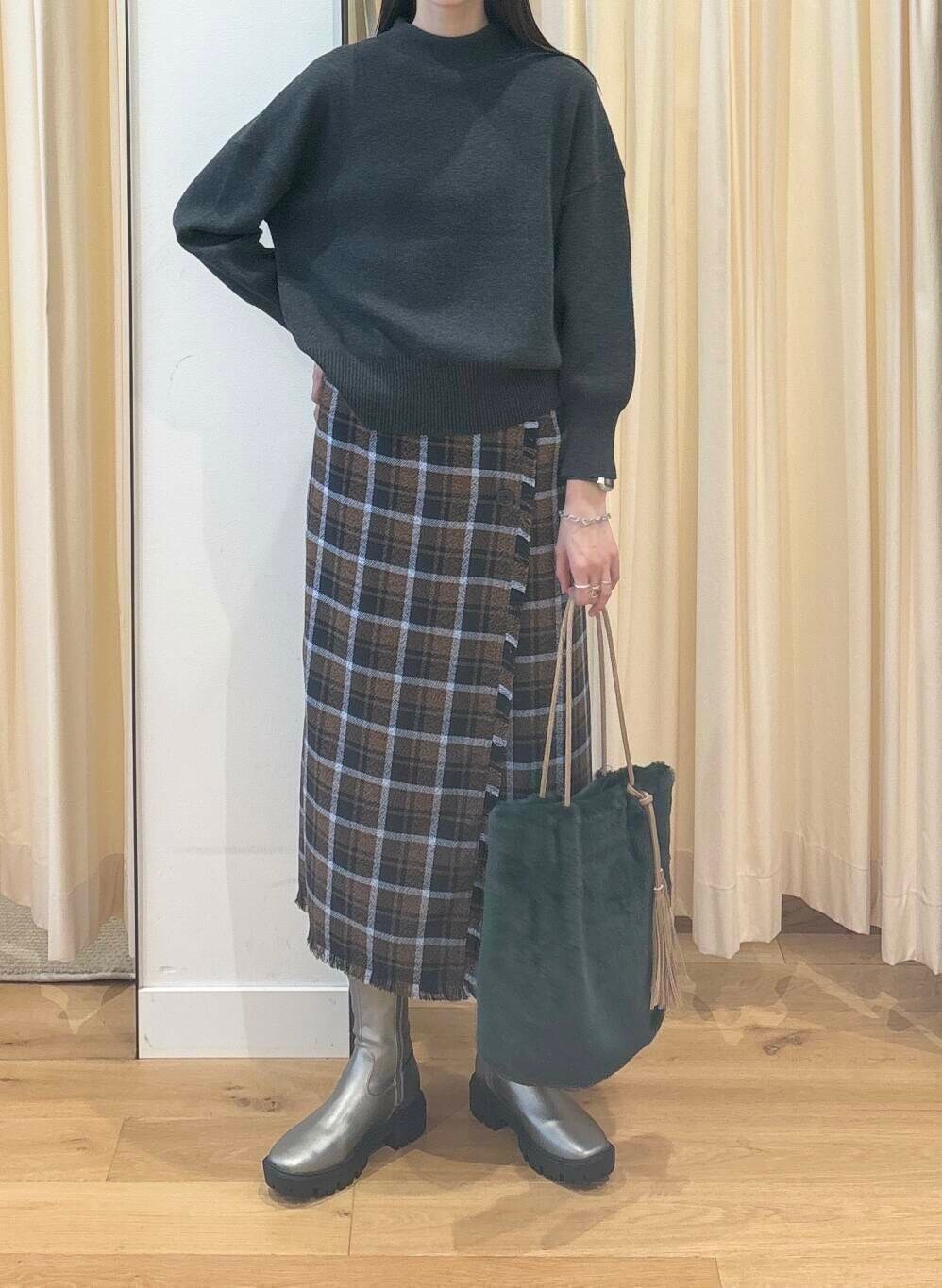 グレー系のニット/セーター、シルバー系のブーツ、ブラウン系のスカートを着用したレディースの秋コーディネートの6枚目の写真