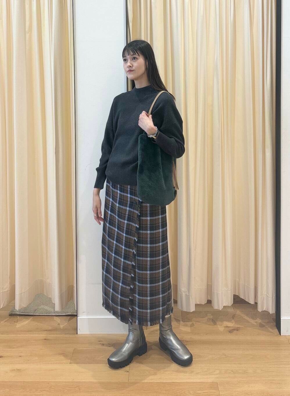 グレー系のニット/セーター、シルバー系のブーツ、ブラウン系のスカートを着用したレディースの秋コーディネートの3枚目の写真