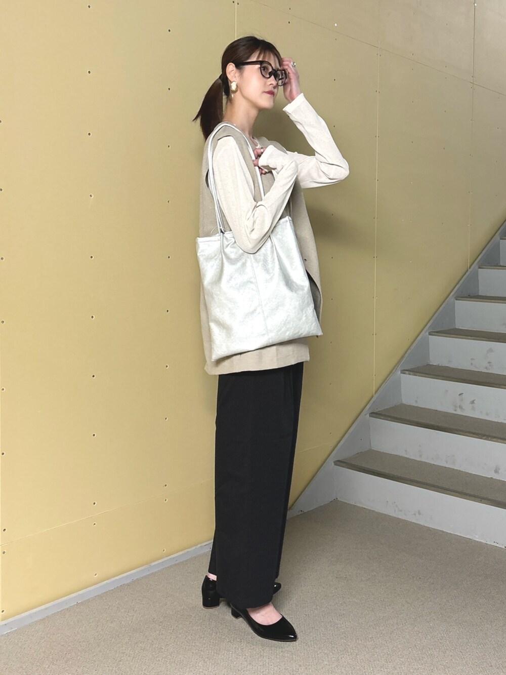 ブラック系のパンプス、シルバー系のトートバッグ、ホワイト系のTシャツ/カットソーを着用したレディースの春コーディネートの4枚目の写真