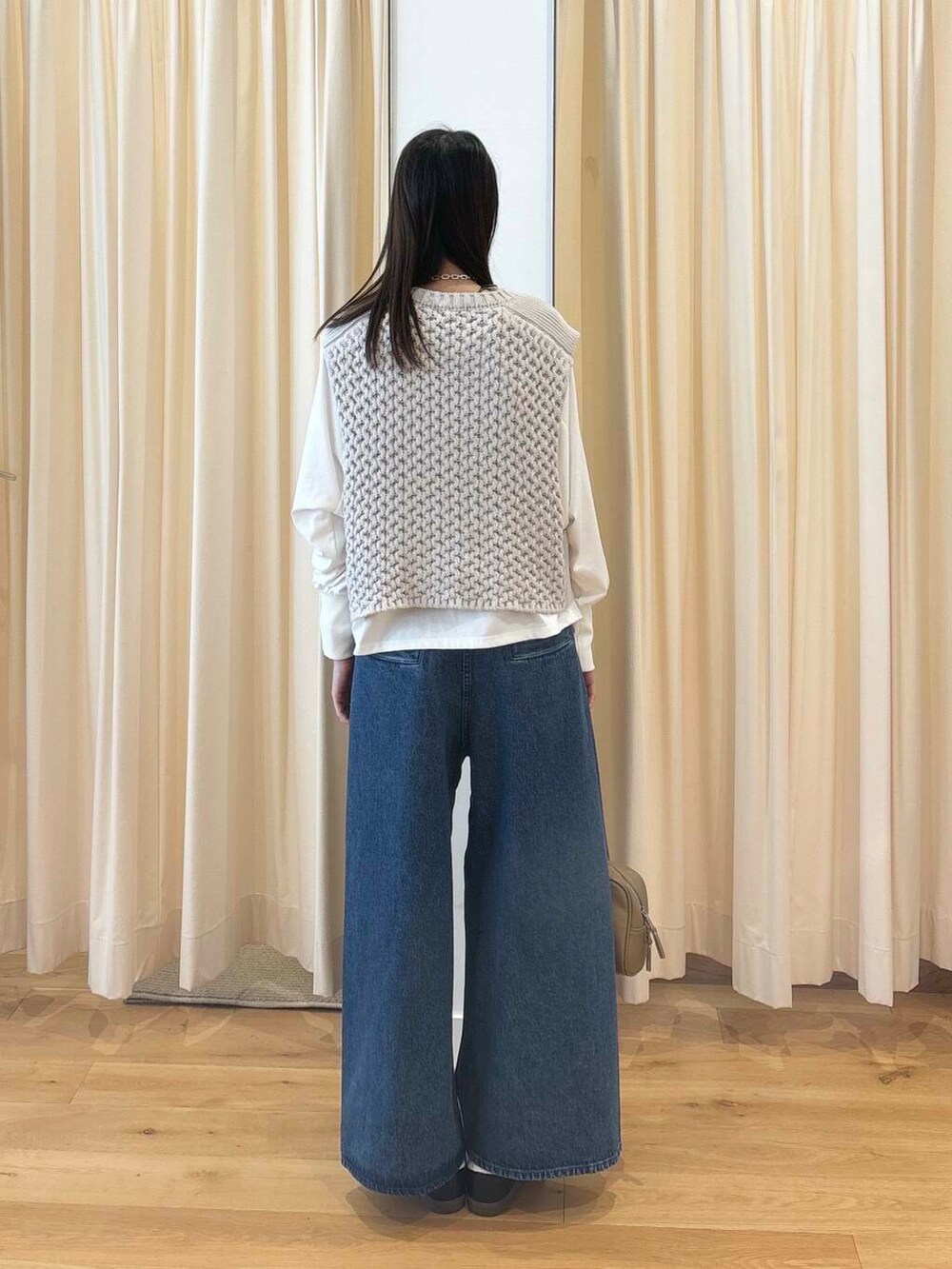 ホワイト系のTシャツ/カットソー、グリーン系のボストンバッグ、ブラック系のスニーカーを着用したレディースの秋コーディネートの4枚目の写真