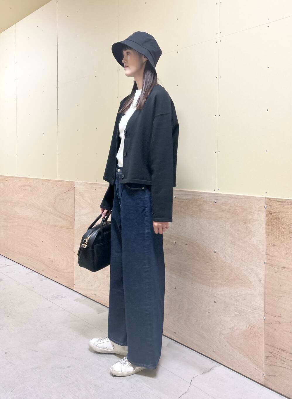 ブルー系のデニムパンツ、ホワイト系のTシャツ/カットソー、ブラック系のボストンバッグを着用したレディースの秋コーディネートの3枚目の写真