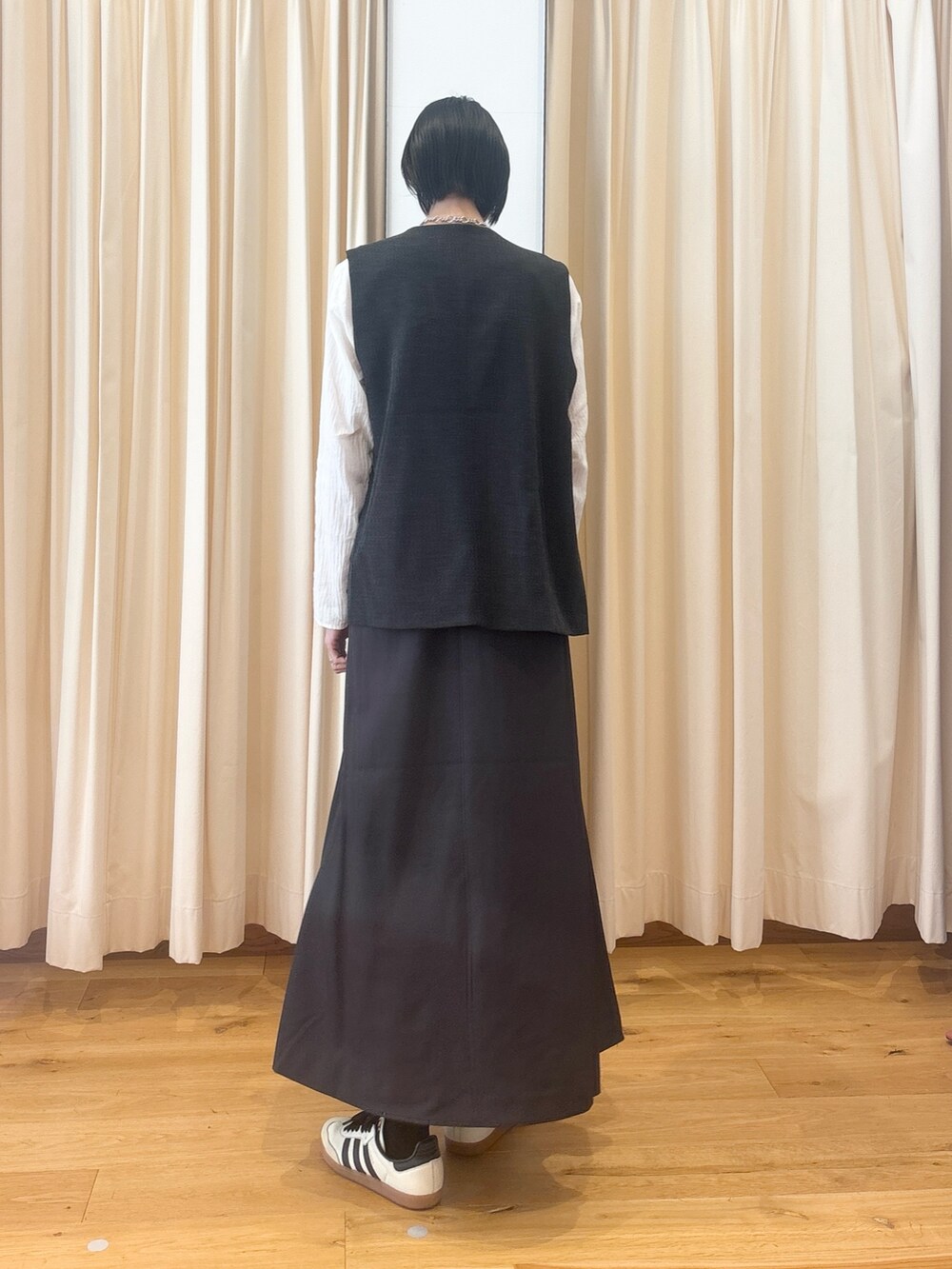ブラック系のその他アウター、ホワイト系のシャツ/ブラウス、グレー系のスカートを着用したレディースの秋コーディネートの4枚目の写真