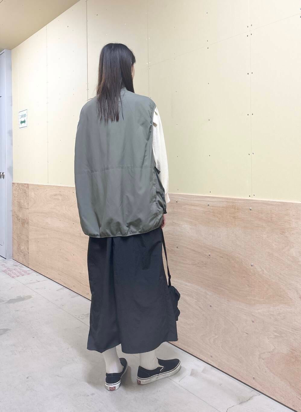 グリーン系のベスト、ブラック系のワンピース、ベージュ系のTシャツ/カットソーを着用したレディースの秋コーディネートの4枚目の写真