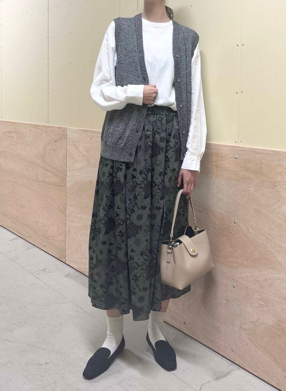 ベージュ系のショルダーバッグ、ブラック系のスカート、ブラック系のローファーを着用したレディースの秋コーディネートの5枚目の写真