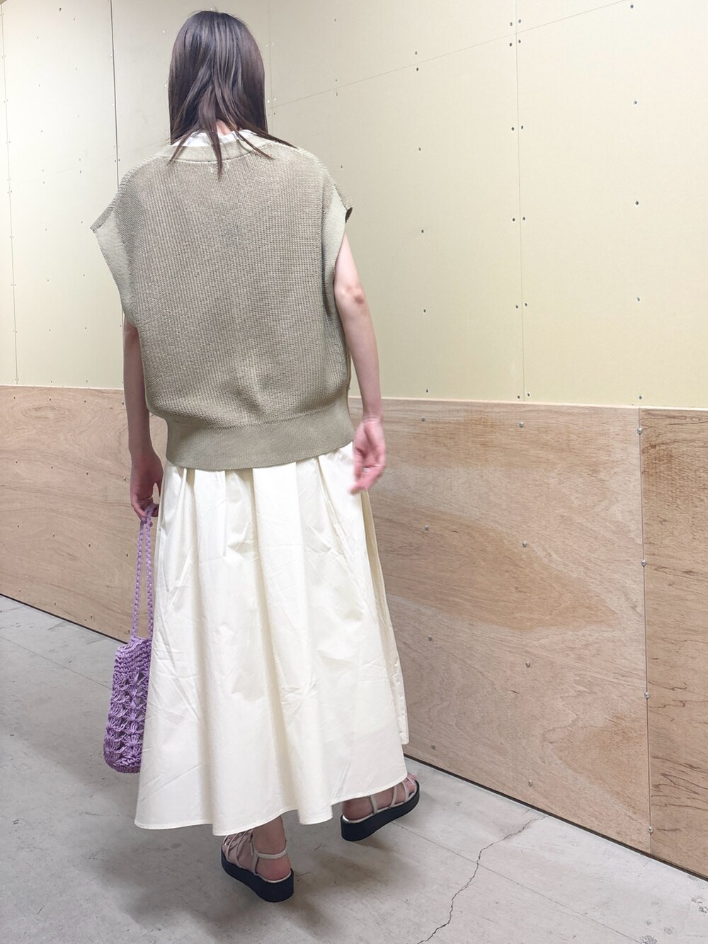 ベージュ系のベスト、ホワイト系のスカート、シルバー系のサンダルを着用したレディースの夏コーディネートの3枚目の写真