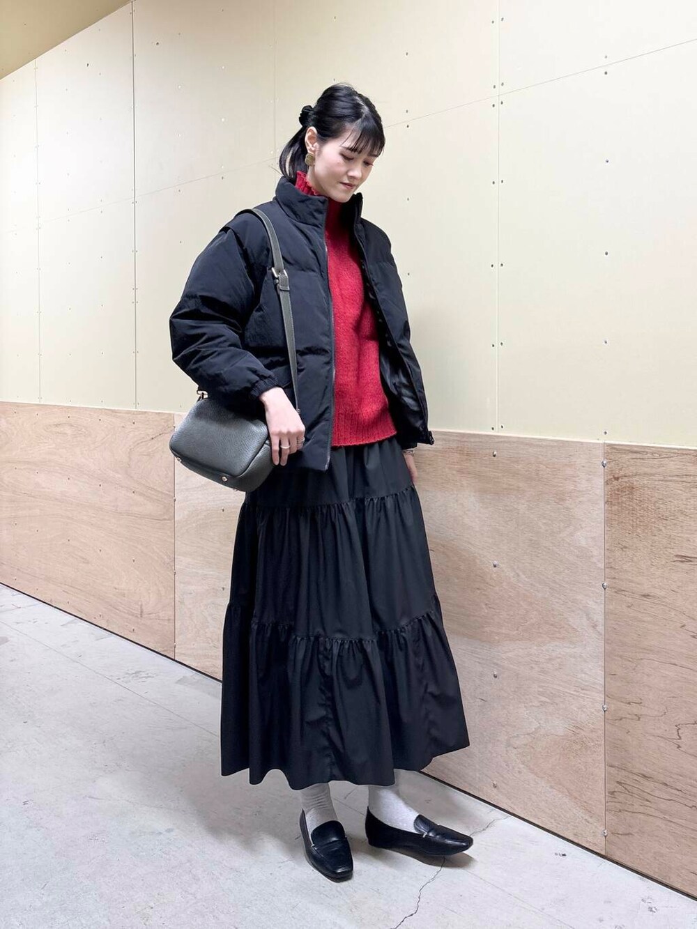 ブラック系のローファー、グリーン系のショルダーバッグ、ブラック系のブルゾンを着用したレディースの冬コーディネートの2枚目の写真