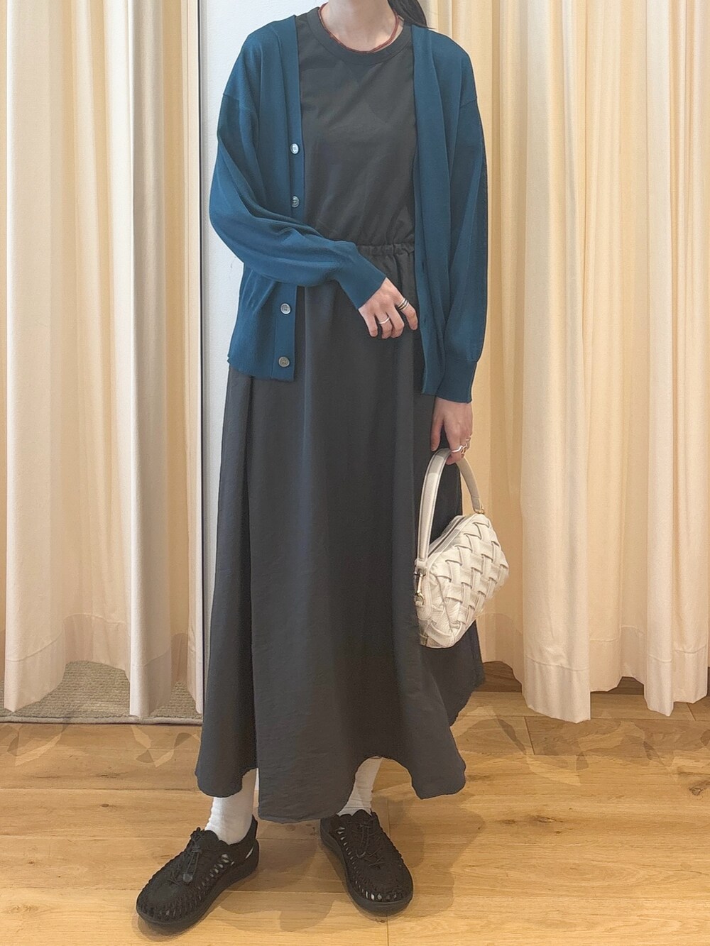 ホワイト系のショルダーバッグ、ブルー系のカーディガン/ボレロ、グレー系のワンピースを着用したレディースの夏コーディネートの8枚目の写真