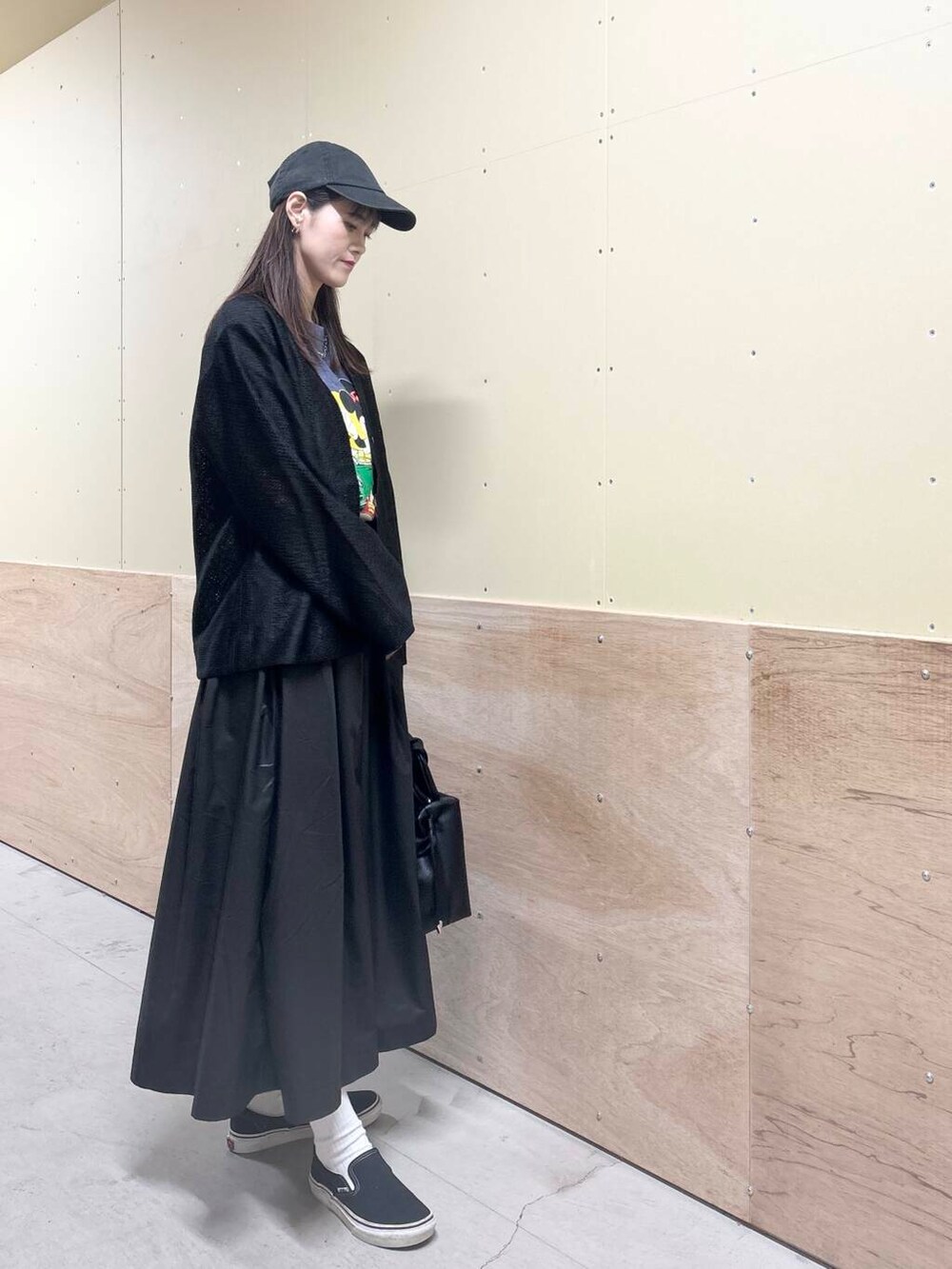 ブラック系のハンドバッグ、ブラック系のスカート、ブラック系のカーディガン/ボレロを着用したレディースの秋コーディネートの4枚目の写真