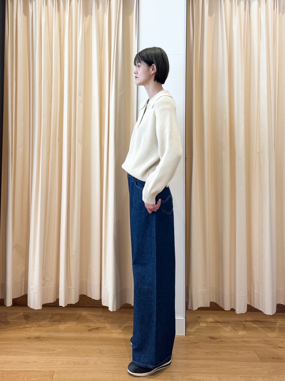 ホワイト系のニット/セーター、ブルー系のデニムパンツを着用したレディースの冬コーディネートの2枚目の写真