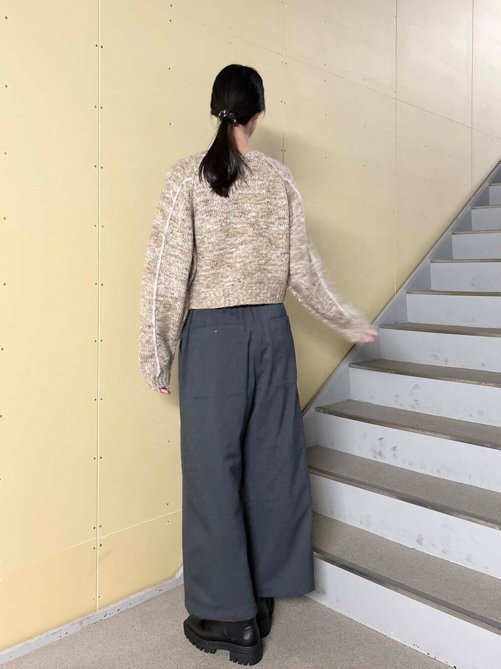 ブラック系のブーツ、ホワイト系のブルゾン、ベージュ系のニット/セーターを着用したレディースの冬コーディネートの6枚目の写真